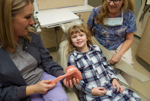 General dentist near Stow Dr. Mica Bartels shows young girl play teeth to answer common questions about children's dental health
